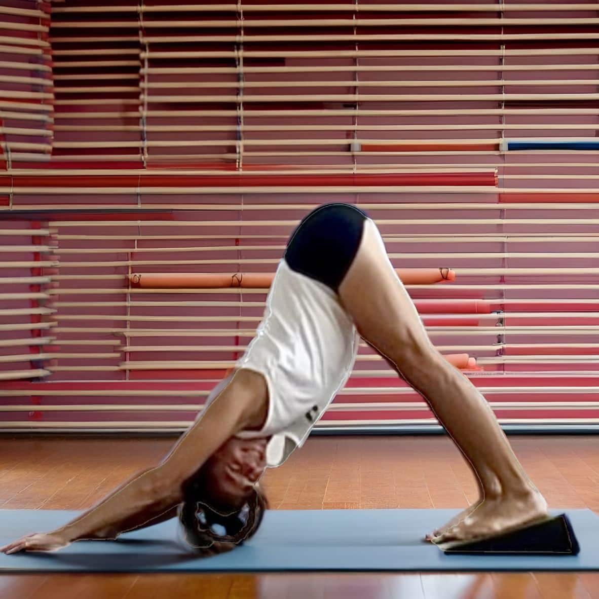 Woman practicing yoga using Flexelent squat wedges