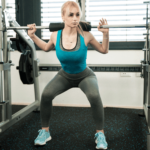 Woman practicing squats at the gym using Flexelent squat wedges for better form