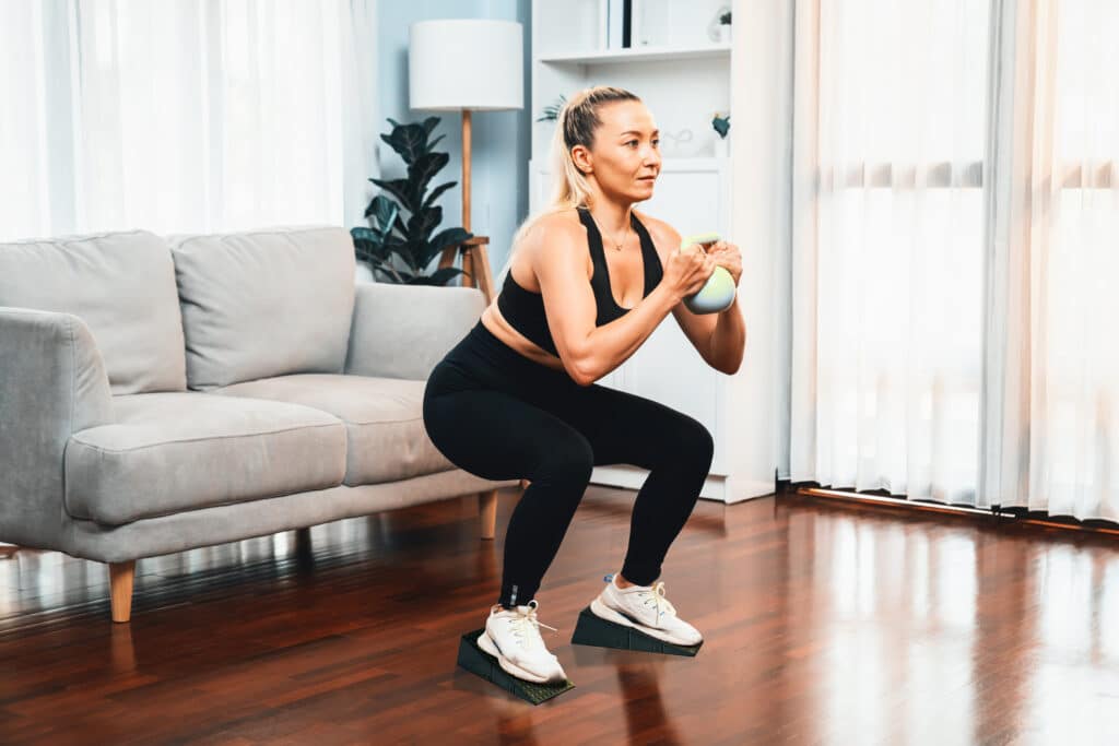 Woman Performing Squats with Home Gym Equipment Using Squat Wedges