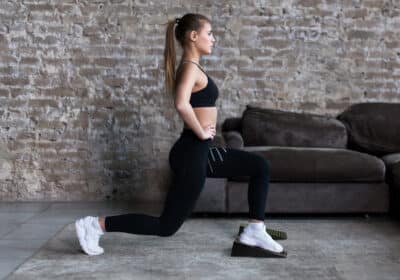 Woman performing elevated lunges using Flexelent squat wedges