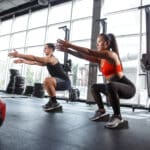 Two people performing versatile workout routines with Flexelent wedges in the gym