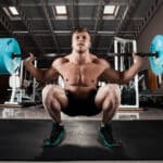 Man performing a deep squat with heavy weights using Flexelent squat wedges